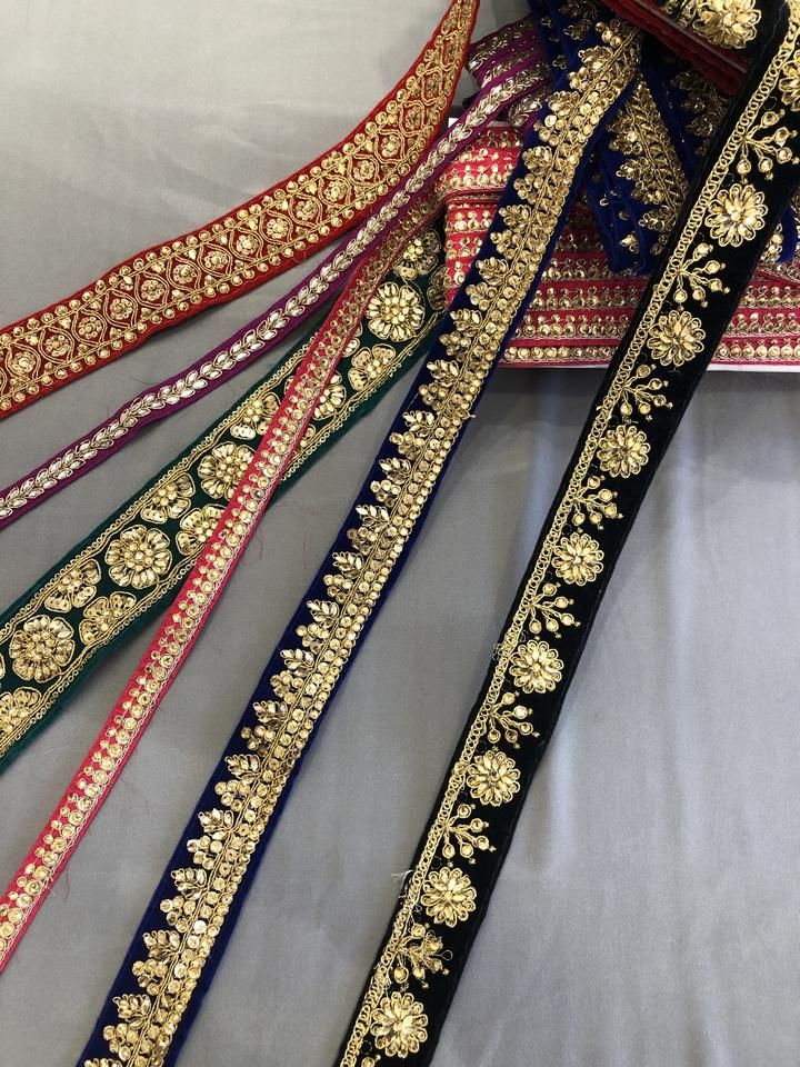 several different colored ribbons with gold and blue trimmings on them, sitting on a white surface