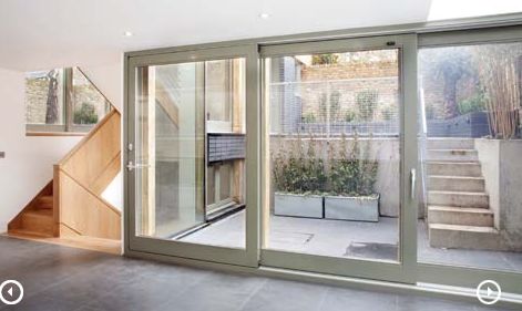 an empty living room with sliding glass doors leading to the back yard and staircases