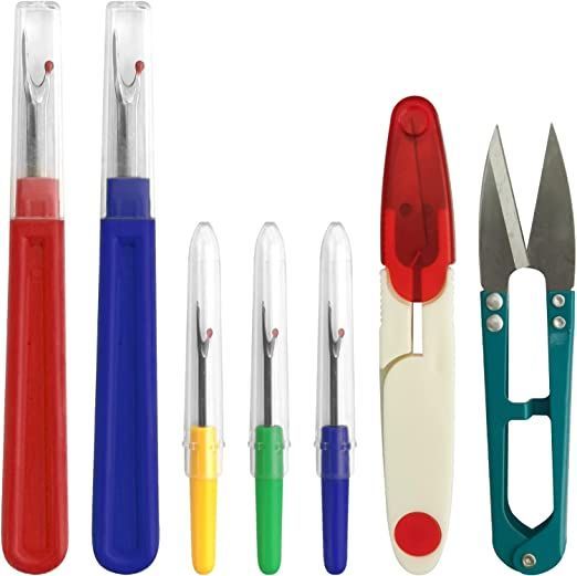 several different colored pens and scissors on a white background