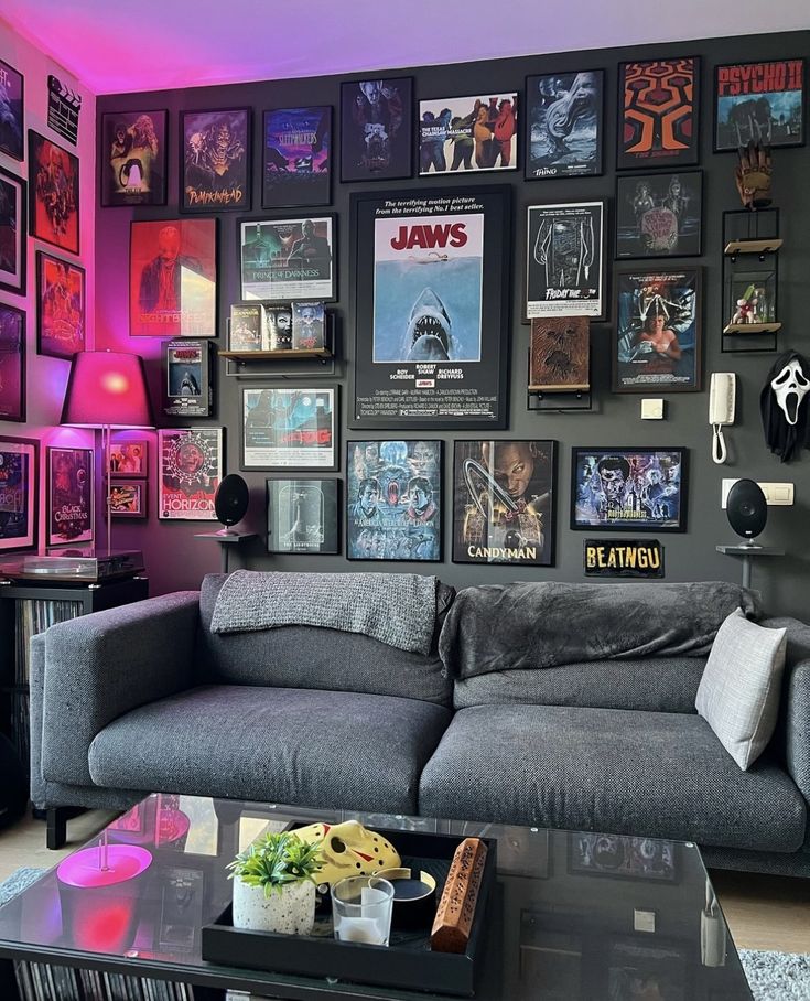 a living room filled with gray couches and pictures on the wall next to a coffee table