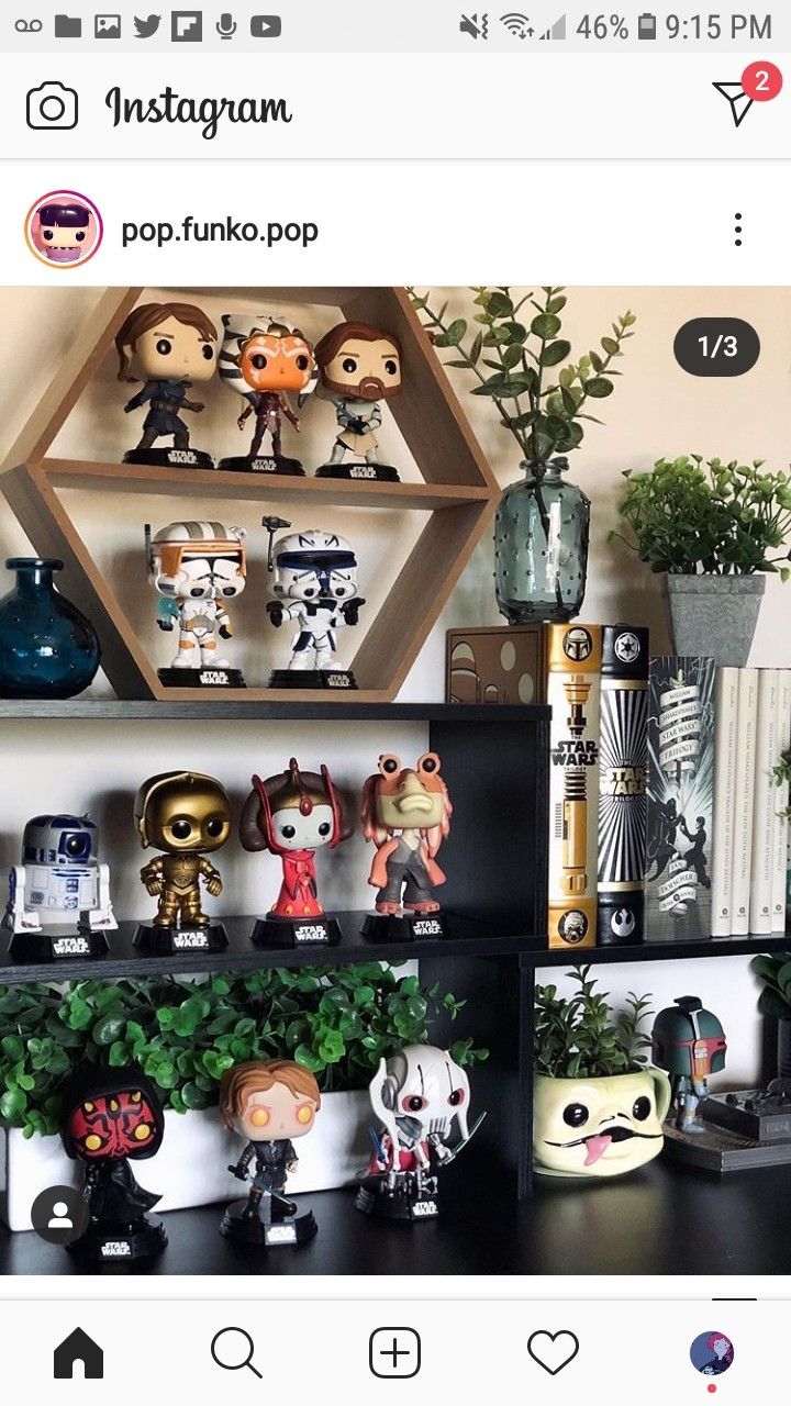 a shelf filled with lots of figurines on top of a black table next to a potted plant