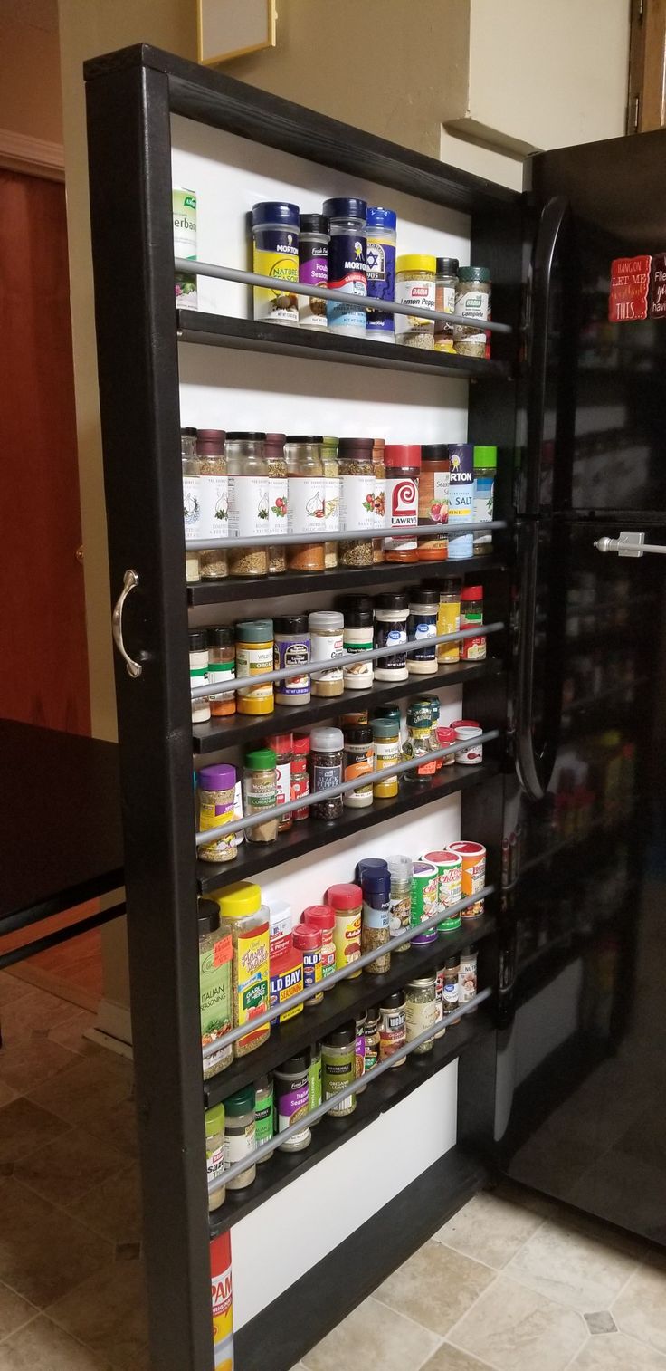 a refrigerator filled with lots of food sitting next to a wall covered in magnets