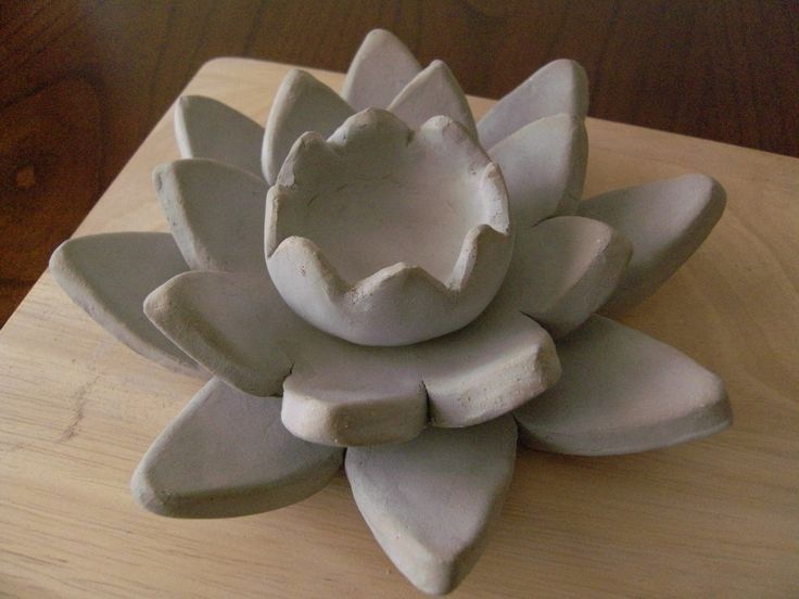 a ceramic flower sitting on top of a wooden table