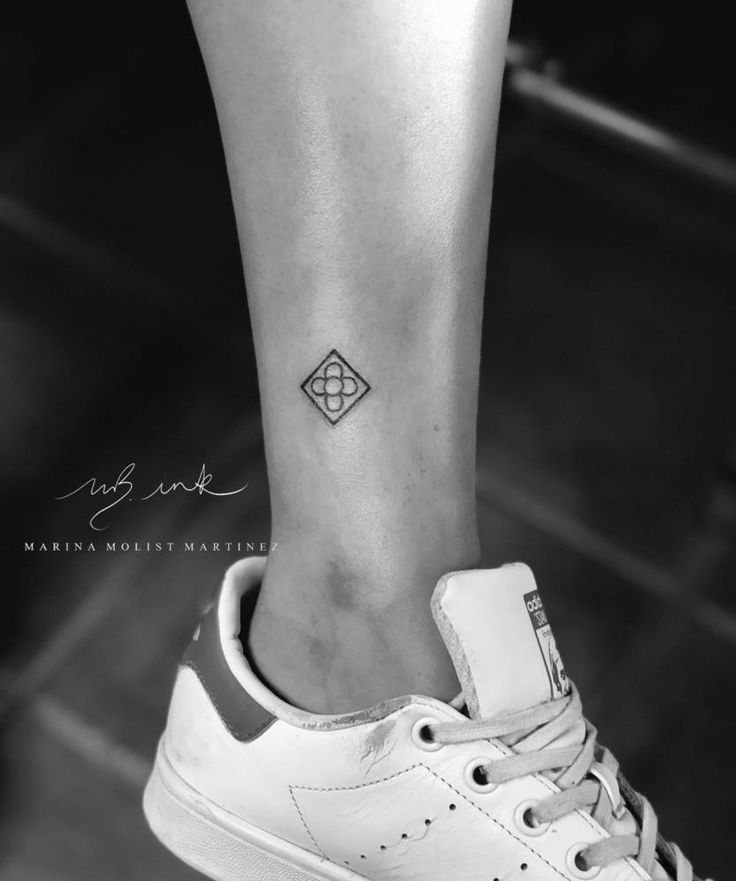 a woman's foot with a small diamond tattoo on the left side of her ankle