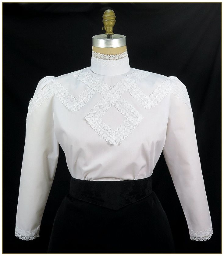 "Cotton/Poly. Color: White. Pima blend broadcloth fabric designed with raschel scalloped white lace trimmed design front. Button back stand up collar and full length gathered sleeves with white lace trim cuffs. Machine washable. Circa 1905-1910. Made in U.S.A. Sizes: SM, MED, LG & XLG. Blouses ordered by bust measurement, inches: BUST SIZES 32\" - 34\" SMALL 35\" - 39\" MEDIUM 40\" - 44\" LARGE 45\" - 49\" XLARGE Blouses ordered by bust measurement, centimeters: SMALL 81 cm - 86 cm MEDIUM 88 Fitted Lace Trim Top For Work, White Lace Tops With Scalloped Edges, Formal Blouse With Lace Trim And Ruffled Collar, Classic Blouse With Lace Cuffs For Work, Elegant Fitted Blouse With Scalloped Edges, Fitted White Tops With Contrast Lace, Elegant Blouse With Scalloped Edges, Classic Fitted Puff Sleeve Blouse, Classic Fitted Blouse With Puff Sleeves