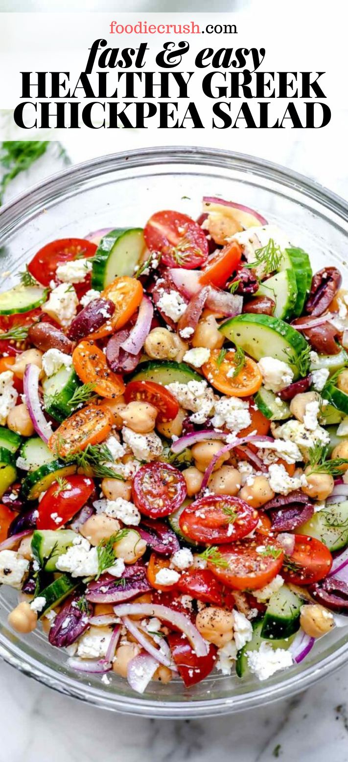 a salad with cucumbers, tomatoes, onions and feta cheese in a glass bowl