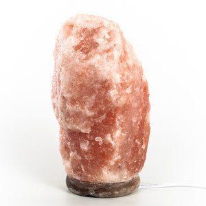 a large pink rock sitting on top of a white table next to a light bulb