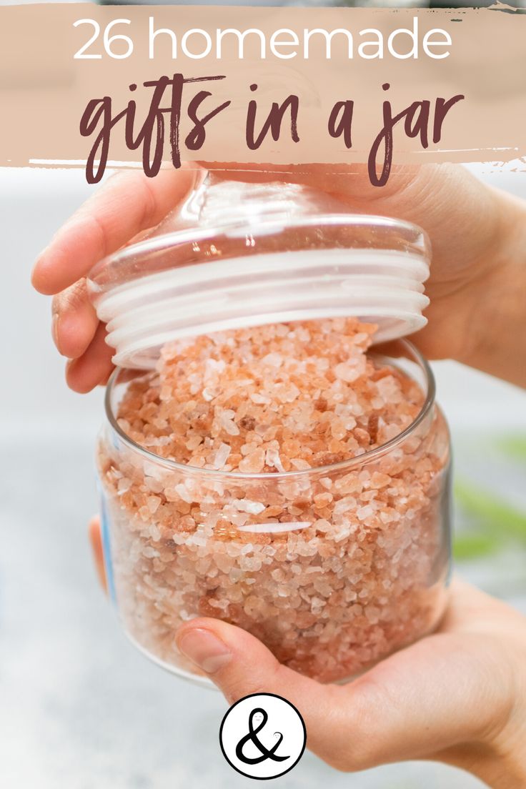 someone holding a jar filled with bath salts and the words homemade gifts in a jar