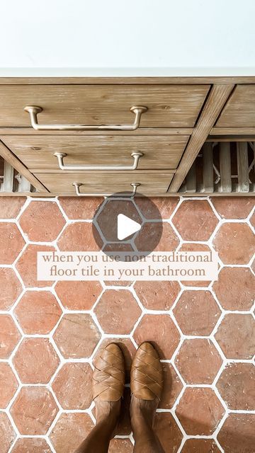 a person standing in front of a tiled floor with the words when you use traditional floor tile, tie in your bathroom