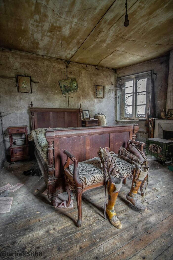 an old room with two wooden benches and chairs in it, one bench is up against the wall