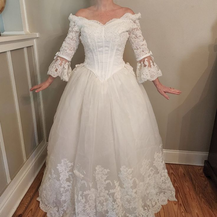 a woman in a white wedding dress is posing for the camera with her hands on her hips