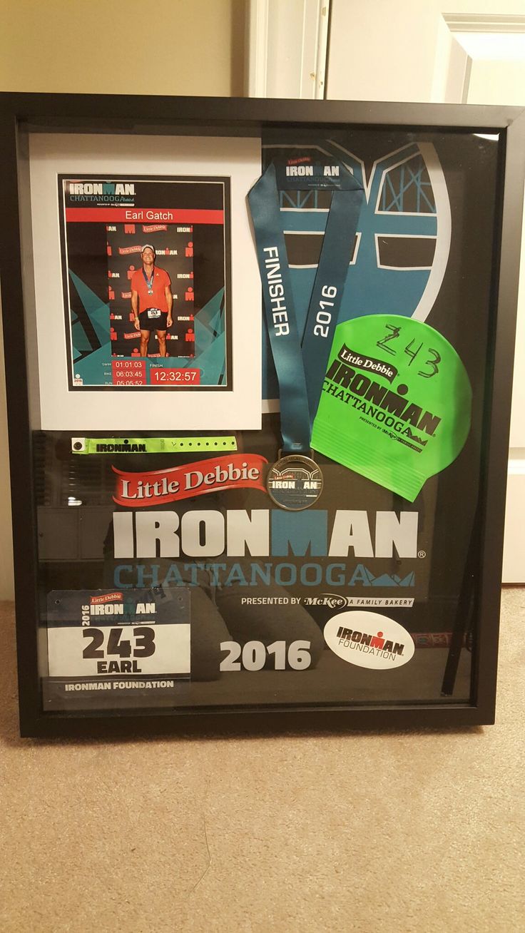 a framed poster with an iron man medal and other items in it's display case