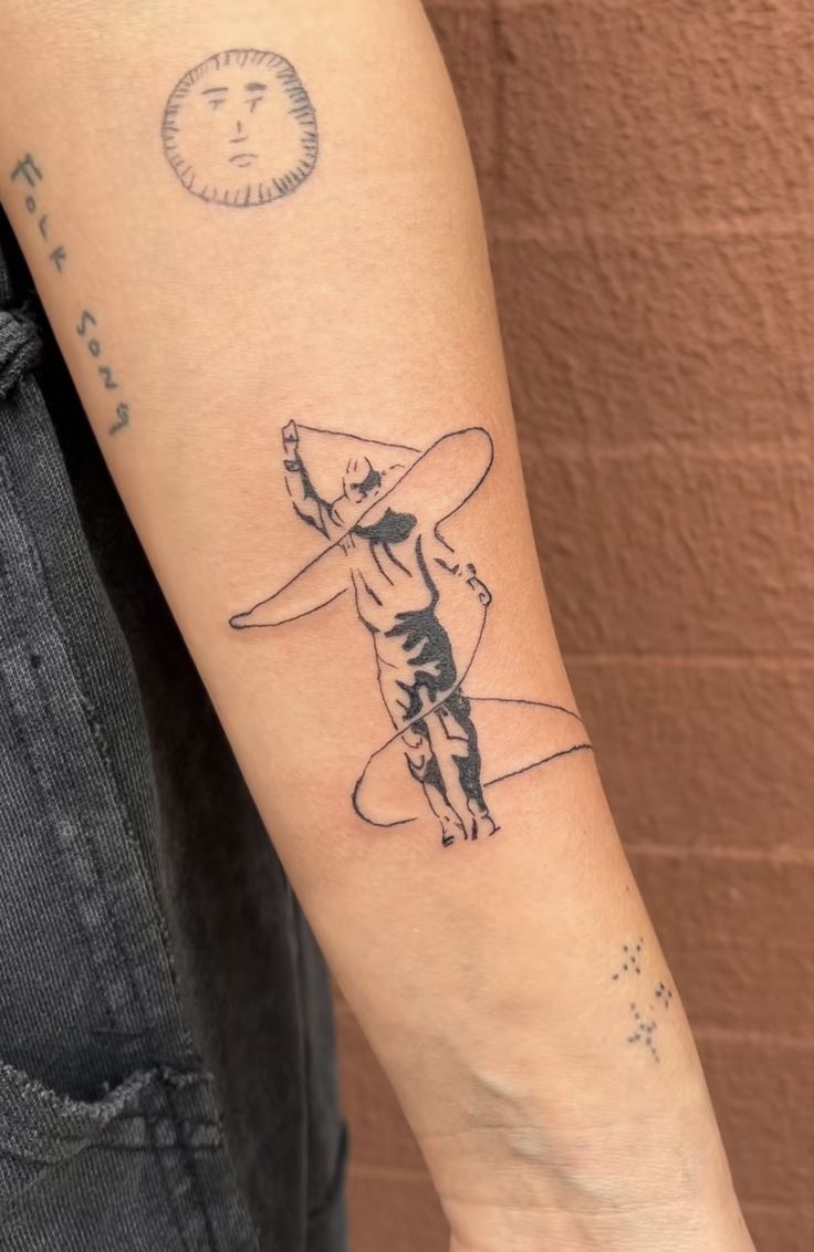 a person with a tattoo on their arm holding a surfboard and pointing to the sky