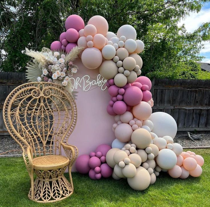 a chair and balloon arch in the grass