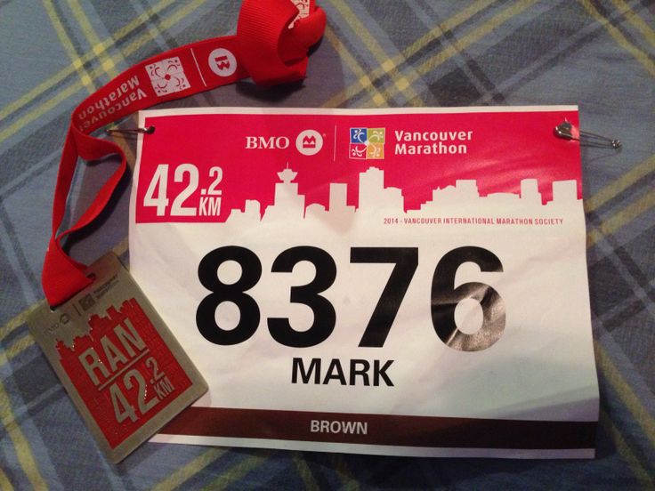 a marathon bib with a red hat and lanyard attached to the back of it