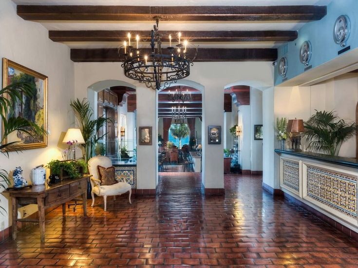 a large foyer with chandelier, chairs and potted plants