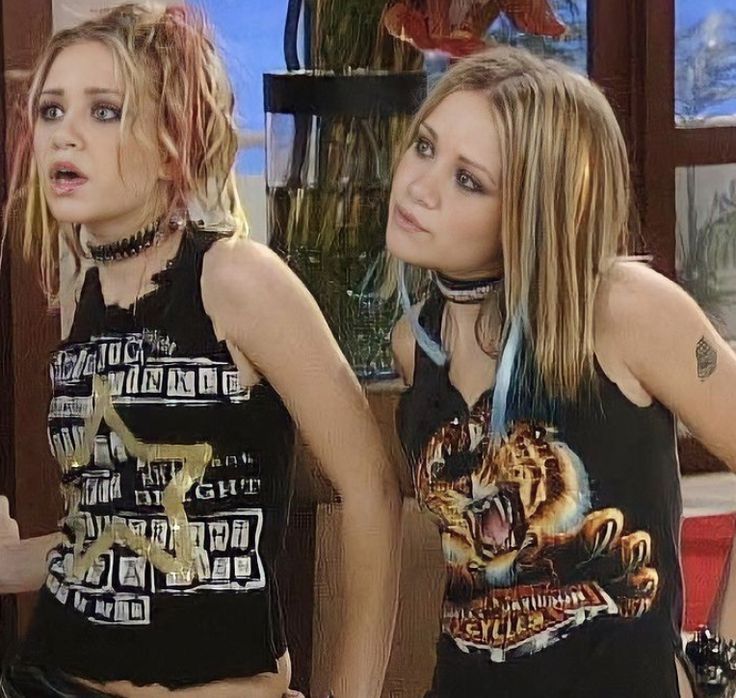 two young women standing next to each other in front of a tv screen with an angry look on their face