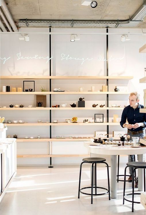 a man sitting at a table in front of shelves filled with food and other items