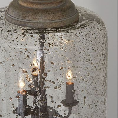 an old fashioned glass light fixture with three candles