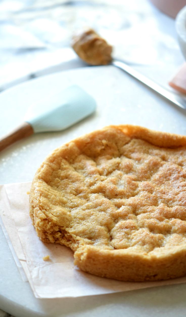 a cookie sitting on top of a piece of paper next to a knife and fork