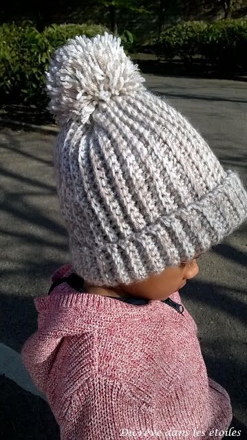 a small child wearing a white knitted hat