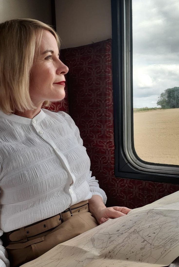 a woman sitting on a train looking out the window