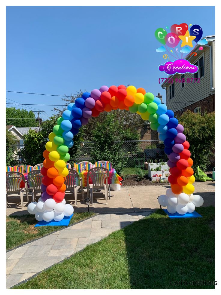 an arch made out of balloons in front of a house