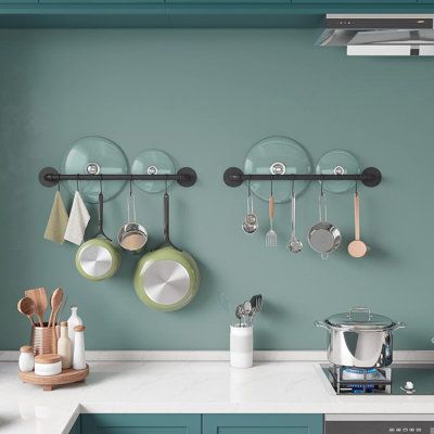 pots and pans hanging on the wall in a kitchen