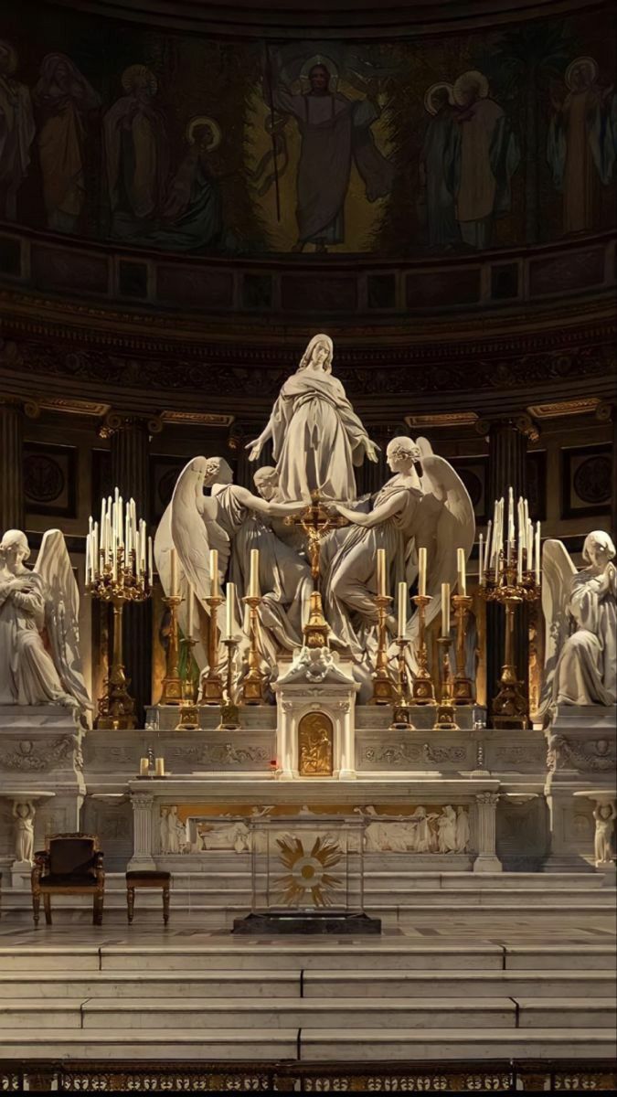 the statue is surrounded by angels and candles in front of an ornate alter with gold accents