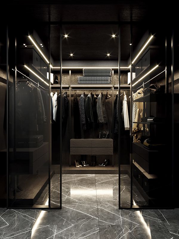 a walk in closet with clothes hanging on the walls and lights shining down from the ceiling