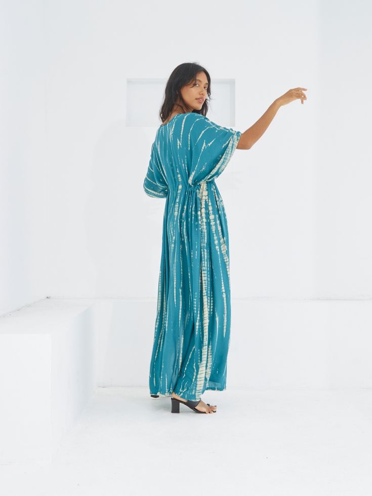 Switch to vacay mode anytime with the Goddess - Tie Dye Kaftan Maxi Dress. This undeniably sexy, breezy maxi dress will have you dreaming of the wind in your hair, the sound of the ocean waves, and the sand under your feet. Experience blissful comfort and breathability whether you’re at home or on vacay with the gorgeous flowy long dress and laid-back loose fit. Crafted in 100% soft, lightweight rayon, this dress features flawless tie-dye patterns and is perfect for tropical beachside vacations, Breezy V-neck Maxi Dress For Poolside, Turquoise Maxi Dress For Beach Cover-up, Turquoise V-neck Maxi Dress For Vacation, Turquoise Maxi Dress For Beach Cover-up In Spring, Flowy Breezy Rayon Maxi Dress, Relaxed Fit V-neck Maxi Dress For Vacation, Breezy Blue Maxi Dress For Beach Season, Rayon Maxi Dress For Vacation, Blue Bohemian Maxi Dress For Poolside