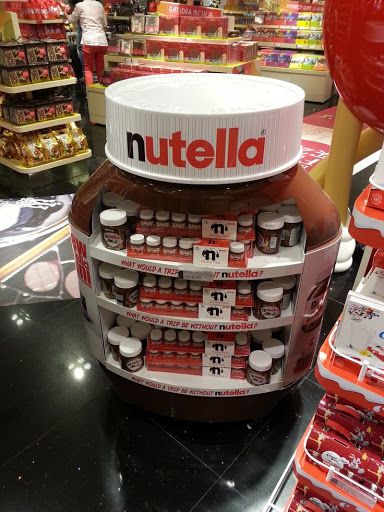 a nutella display in a store filled with lots of bottles and containers on top of each other