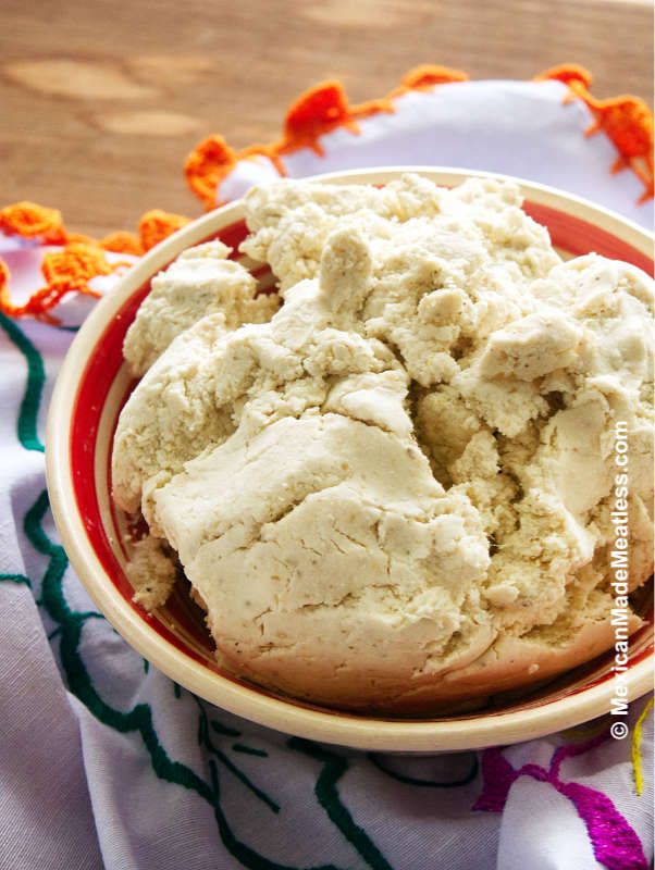 a bowl filled with ice cream on top of a white and orange cloth next to a wooden table