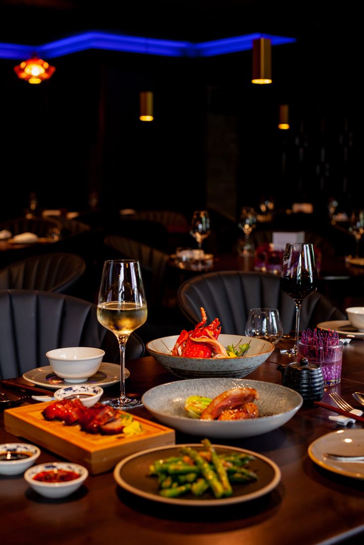 the table is set with many different foods and wine glasses