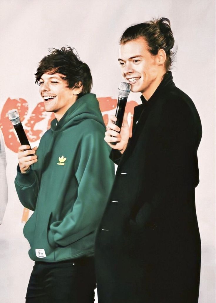 two men standing next to each other holding microphones