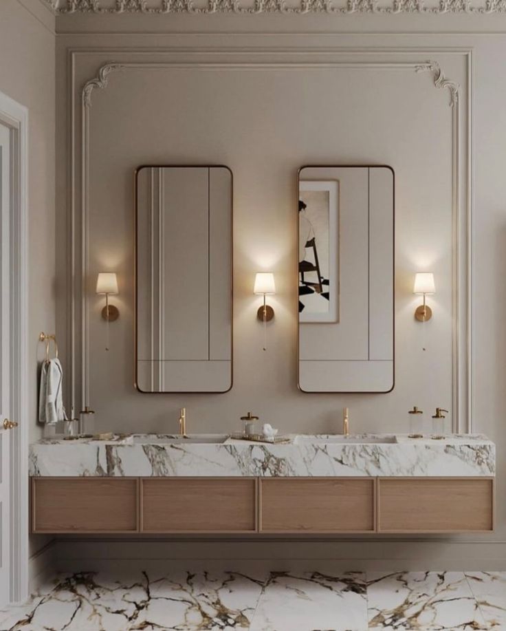 a bathroom with marble counter tops and two mirrors on the wall next to each other