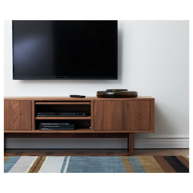 a flat screen tv sitting on top of a wooden entertainment center next to a rug