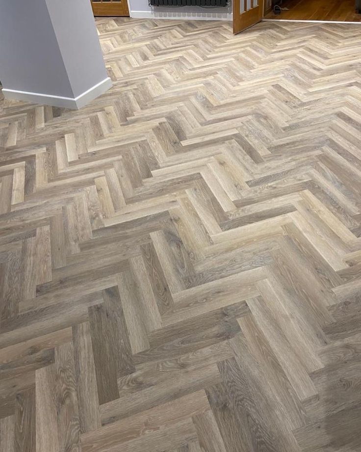 an image of a wood floor in the living room or dining room that looks like herringbones