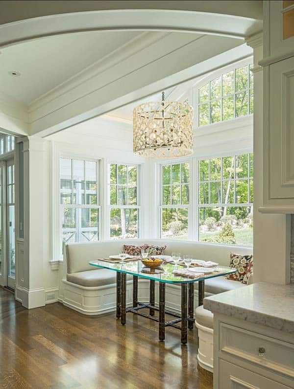 a living room filled with furniture and a chandelier hanging from the ceiling in front of a window