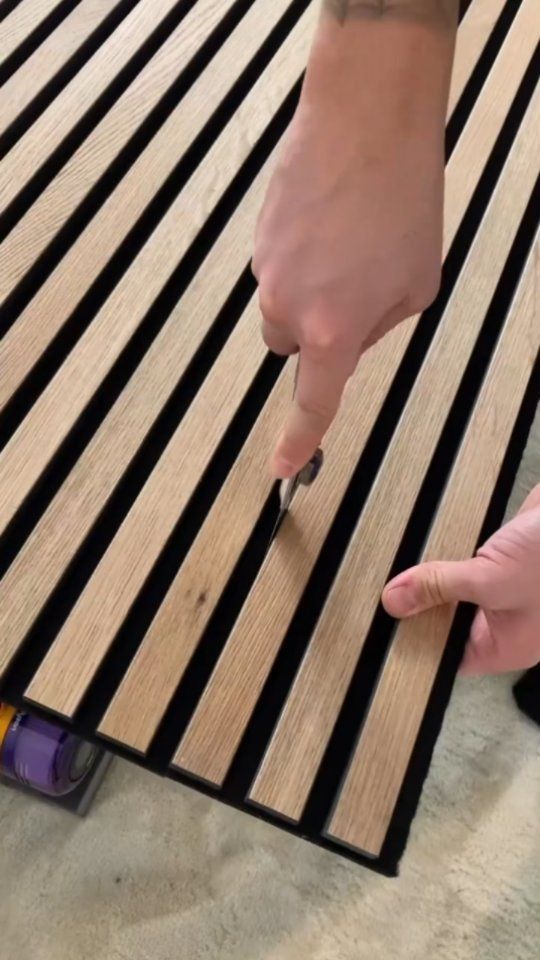 two hands are working on a wooden floor