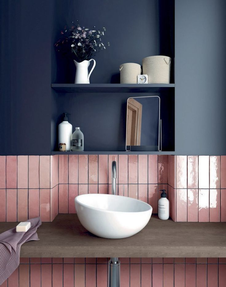 a white bowl sink sitting on top of a wooden counter next to a shelf filled with bottles