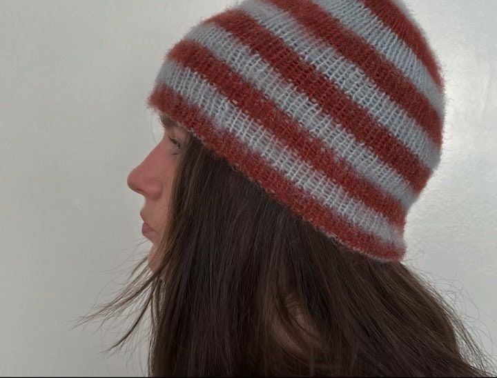 a woman wearing a red, white and blue striped knitted hat with long hair