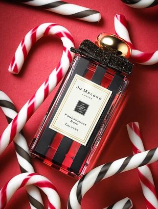 a bottle of jo malone's peppermink cologne next to candy canes