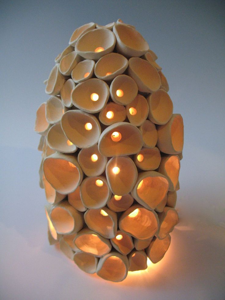 a candle holder made out of cups with candles in the shape of an egg on top