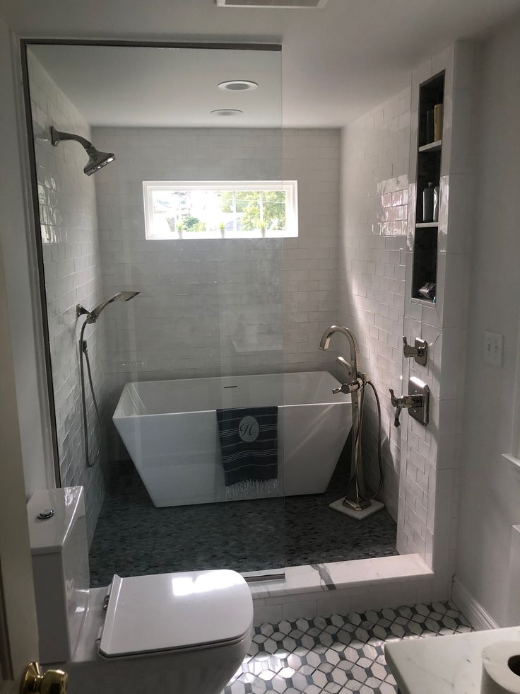 a bathroom with a tub, toilet and sink in it's own shower stall