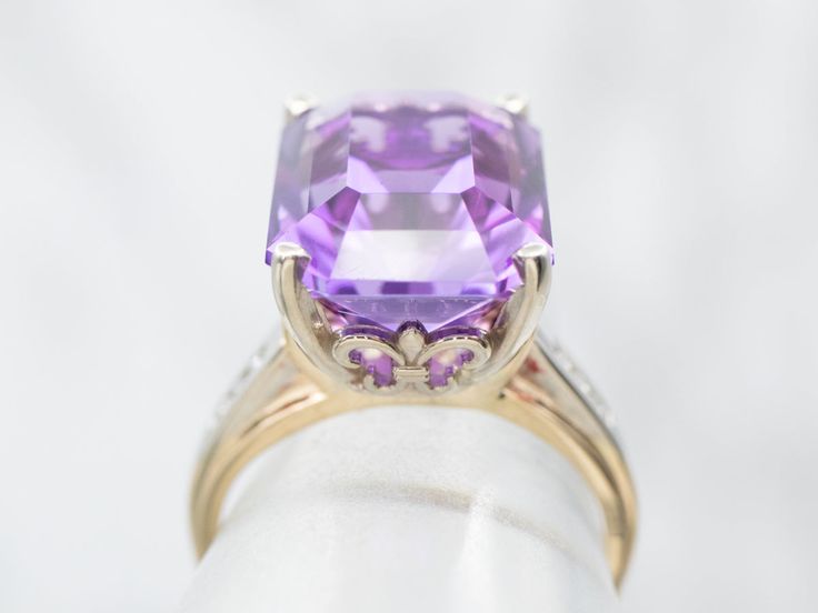 This stunning vintage amethyst ring has a pretty medium-hued purple amethyst in the center, that really flashes and flickers with vibrant violet reflections! Set into a lovely retro era mounting with structurally designed diamond shoulders and simple corner prongs, this vintage ring is a beautiful addition to anyone’s collection!Metal: 14K Yellow and White GoldGem: Amethyst 9.81 CaratsGem Measurements: 15.3 x 11.2 mm, Emerald CutAccents: 6 Diamonds totaling .06 Carats, SI2 in Clarity, K in ColorRing Size: 5.75Marks: “14K” Stamped on the inside band Vintage Amethyst Ring, Garnet Statement Ring, Channel Set Diamond Band, Amethyst Ring Vintage, Retro Era, Amethyst And Diamond Ring, Engagement Ring Diamond Cut, Tanzanite Ring, Diamond Cocktail Rings