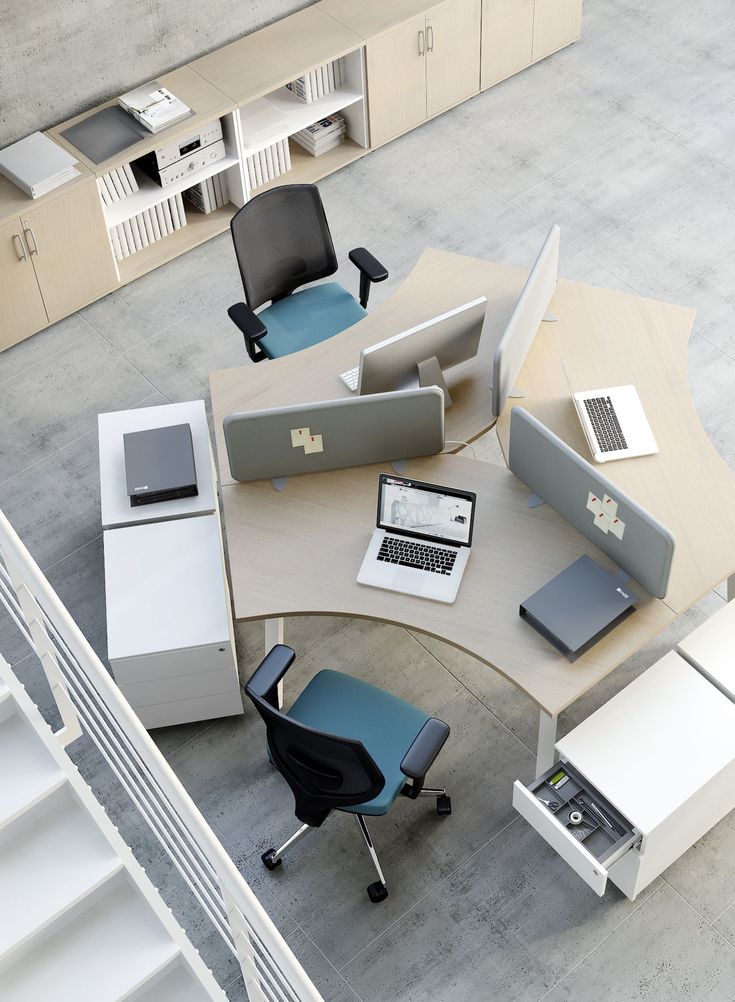 an overhead view of a desk with chairs and laptops