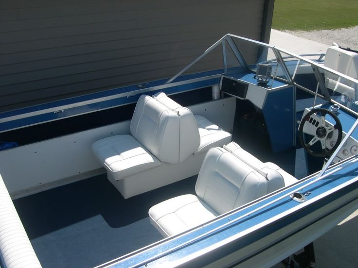 the inside of a boat with two seats and steering wheel on the back deck,