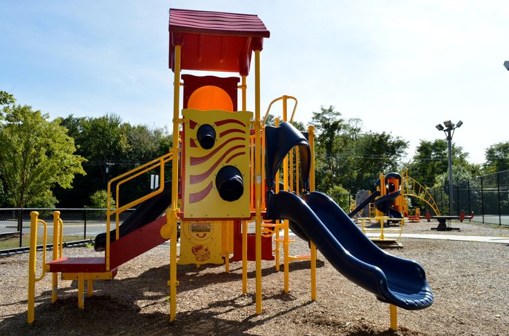 children's play area with slide, climbing frame and playground equipment in park setting