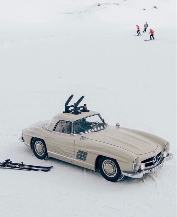 an old car with skis on top in the snow